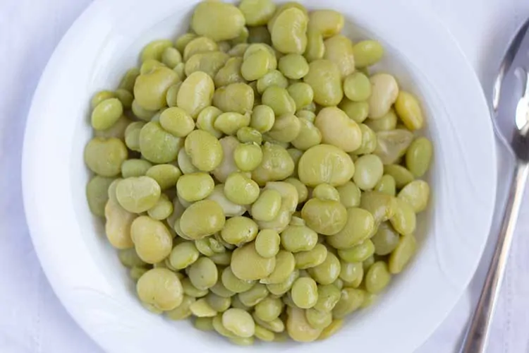 Lima beans in white bowl, pictured from above.