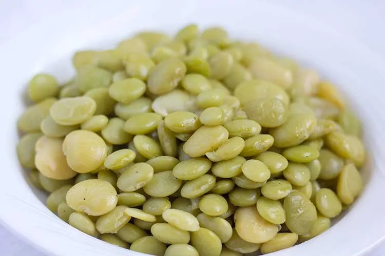Close up of lima beans in white bowl.
