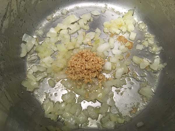 Onions, ginger, and garlic sautéing in pot.
