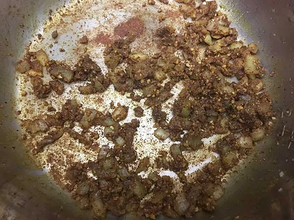 Aromatics sautéing in pot mixed with curry powder.