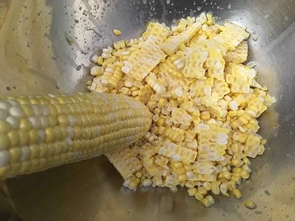 Cutting kernels from corn cobs.