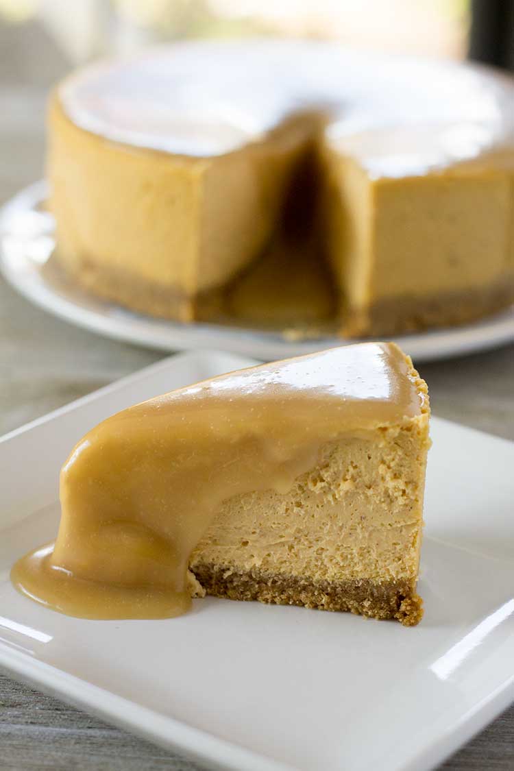 Slice of Instant Pot Pumpkin Cheesecake with maple glaze poured over.
