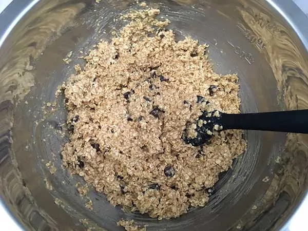 baked oatmeal batter with chocolate chips in mixing bowl with spatula