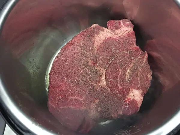 uncooked chuck roast searing in Instant Pot