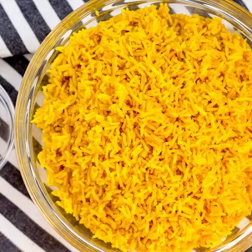 Yellow rice in a clear glass bowl.