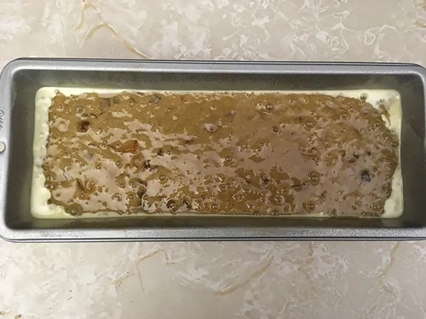 loaf pan filled with uncooked fruit cake batter