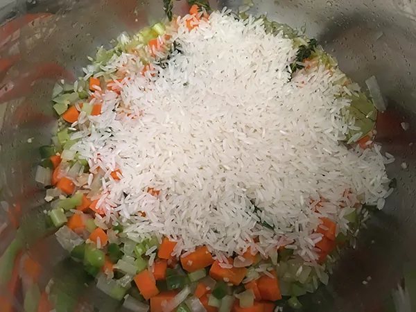 onions, carrots, and celery, topped with uncooked rice