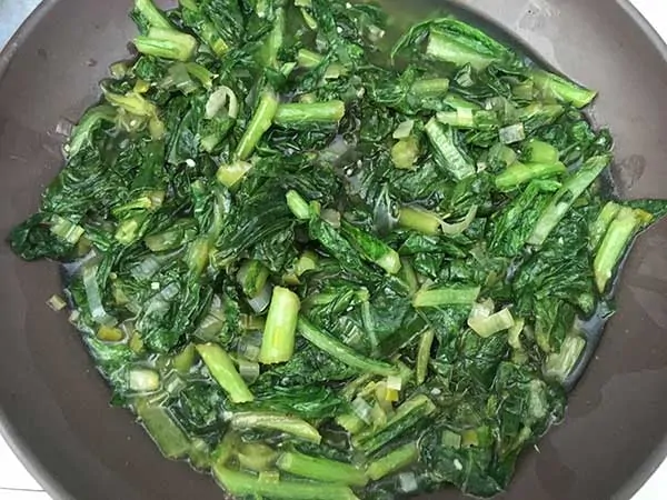 cooked turnip greens in brown bowl