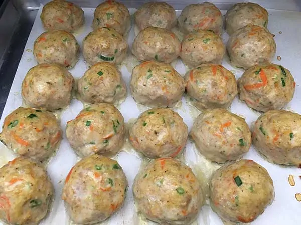 chicken and sausage meatballs on parchment paper