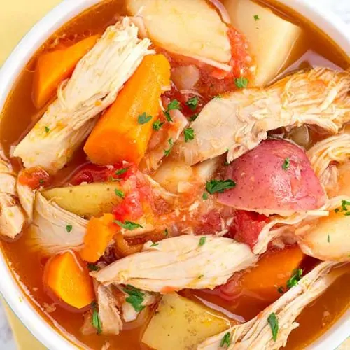 chicken stew in white bowl with yellow napkin