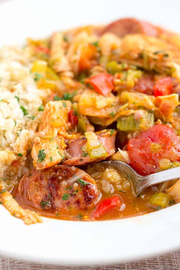 Gumbo soup in white bowl with spoon.