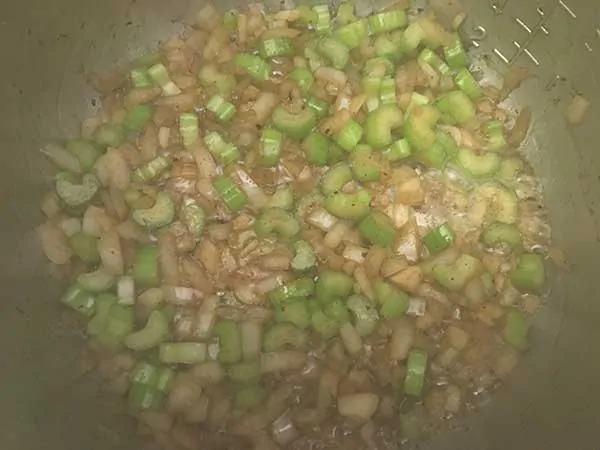 Sautéing diced onions and sliced celery.