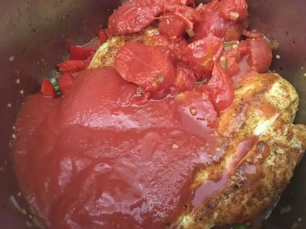 Tomato sauce and stewed tomatoes pour over chicken breasts.
