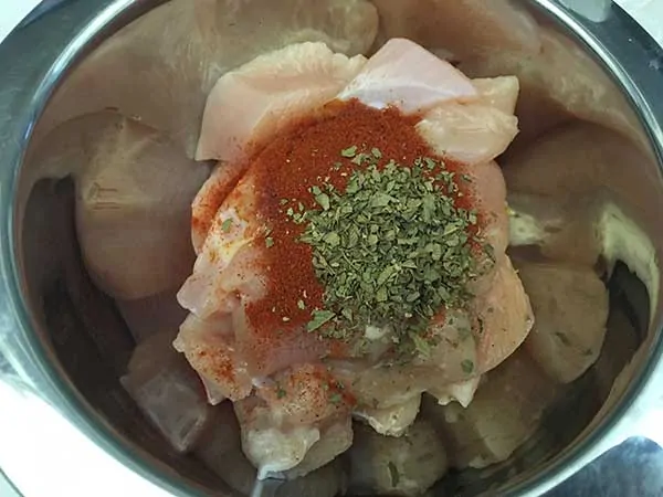 diced chicken breast in bowl with seasonings