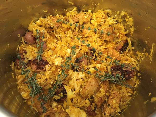 grated cauliflower and sausage seasoned with salt and turmeric, topped wit fresh thyme