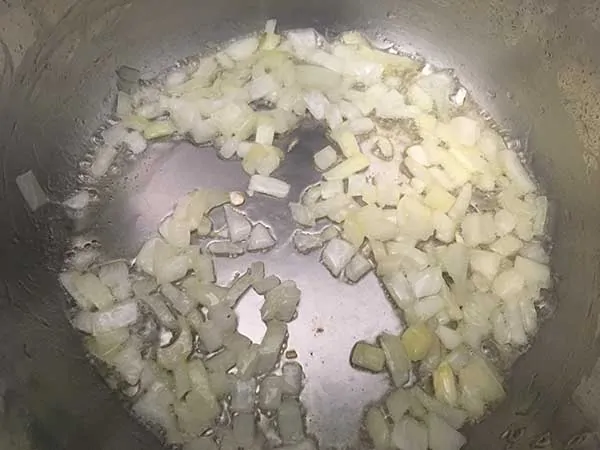 diced onions in Instant Pot with oil and salt
