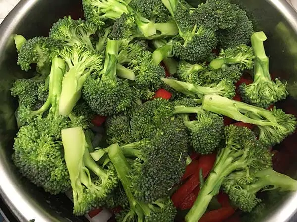 Broccoli florets on top of red peppers.
