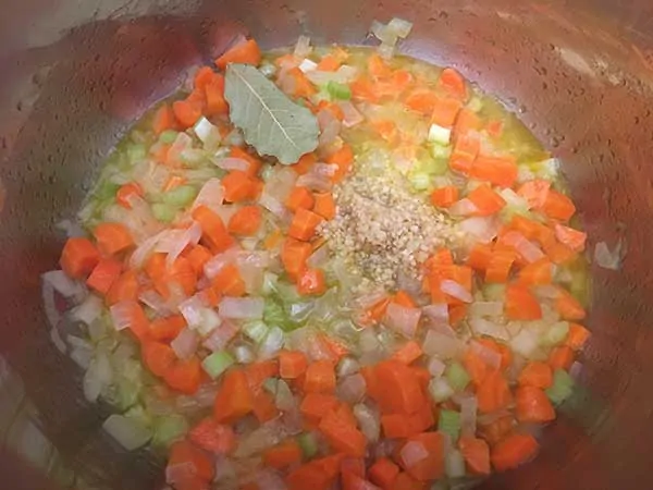 diced onions, carrots, celery, garlic, and bay leaf sautéing in oil