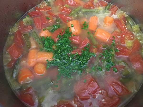 cooked tomatoes, potatoes, carrots, and green beans topped with parsley