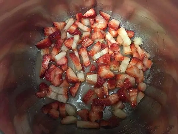 Sliced strawberries in Instant Pot with melting sugar.