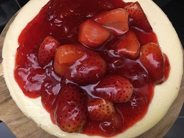 Strawberry glazed poured over cheesecake.