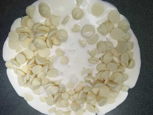 white chocolate chips and heavy cream in small bowl