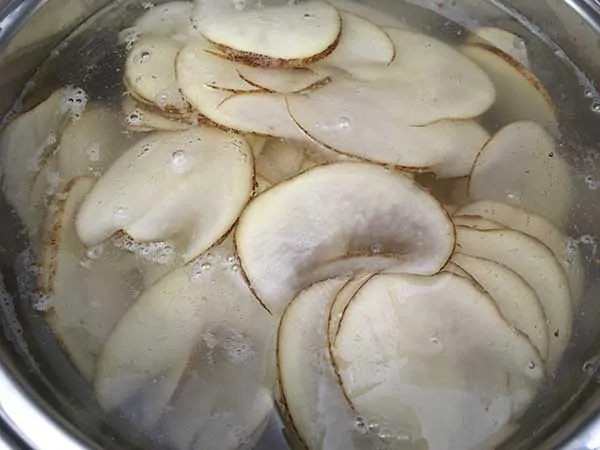 thinly sliced potatoes soaking in water
