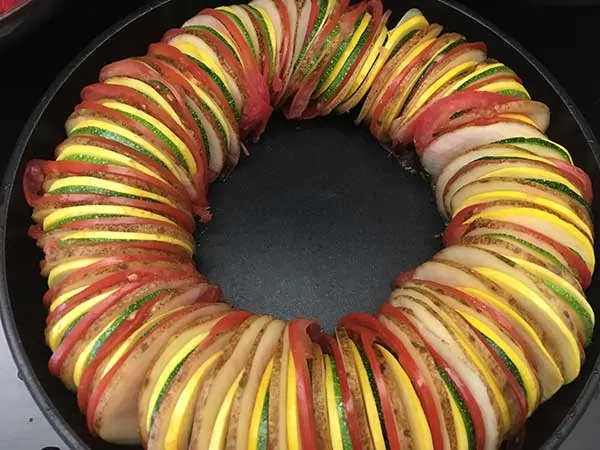thinly sliced potatoes, tomatoes, zucchini, and squash in ratatouille pattern