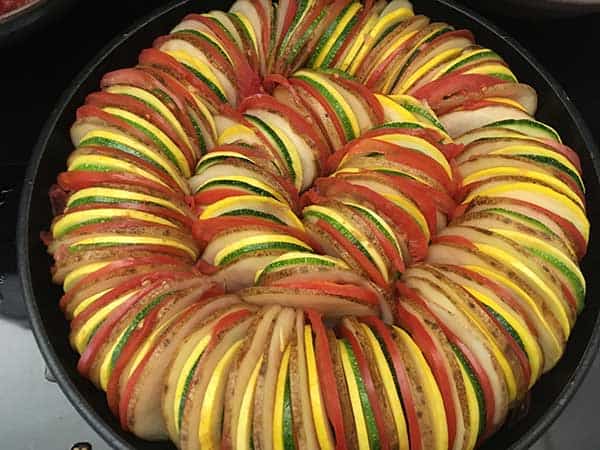 thinly sliced potatoes, tomatoes, zucchini, and squash in ratatouille pattern