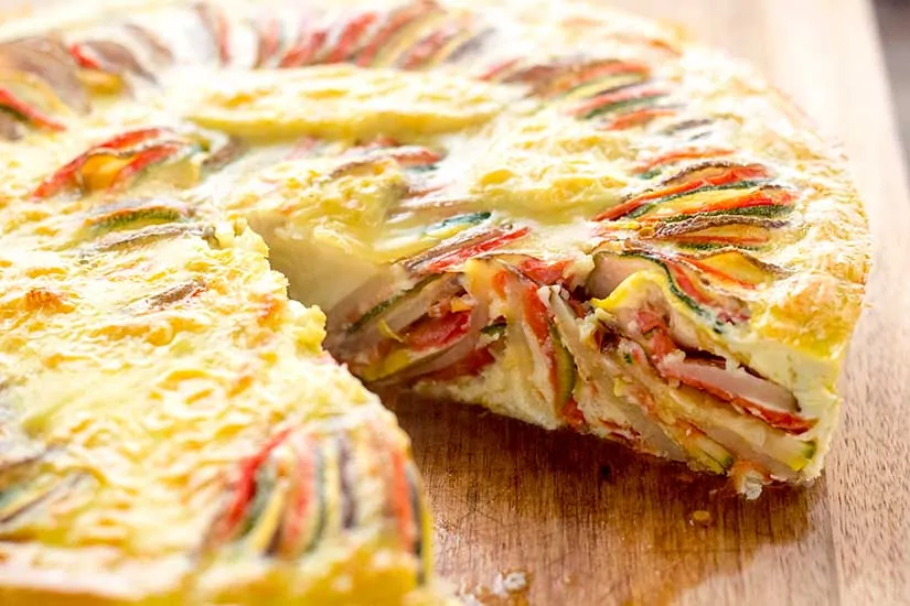 ratatouille frittata sliced on wooden cutting board