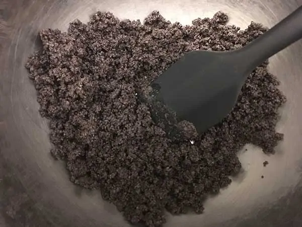crumbled Oreos in mixing bowl with black spatula