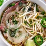 Beef pho in white bowl.