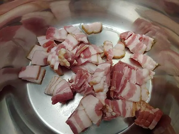 Uncooked bacon pieces in Instant Pot.