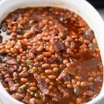 Baked beans in white casserole dish.