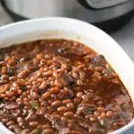 Baked beans in white casserole dish.