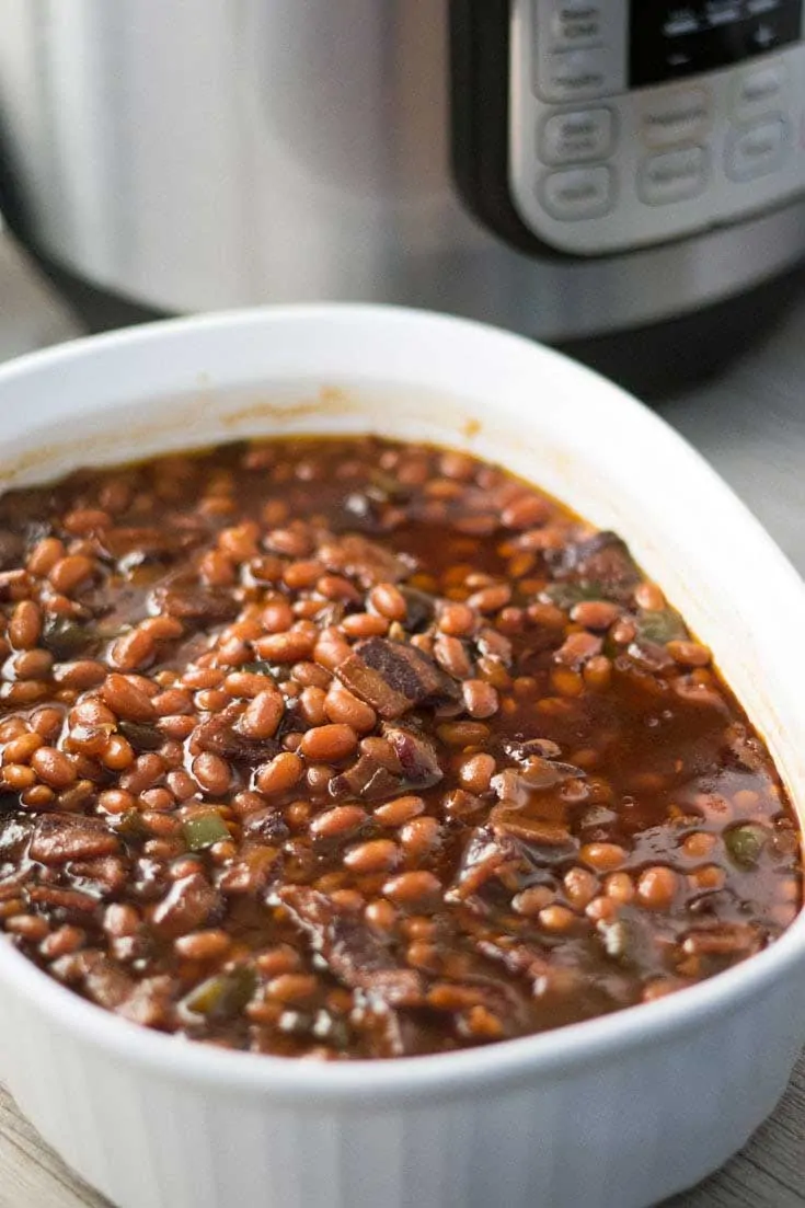 Baked beans in white casserole dish.