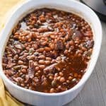 Baked beans in white casserole dish.