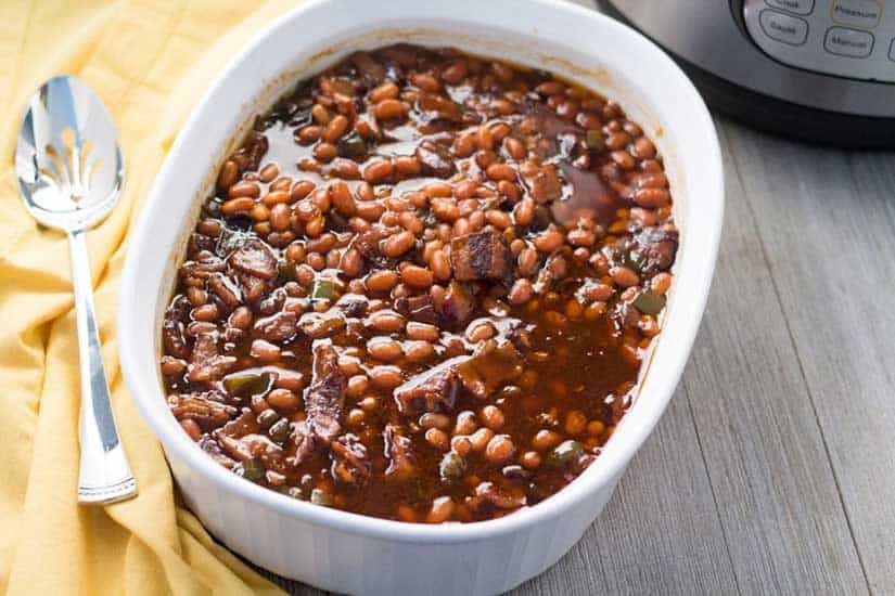 Baked beans in white casserole dish.
