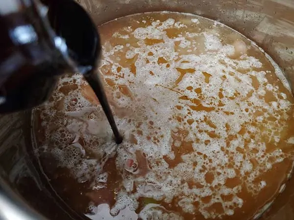 Pouring molasses into pot.