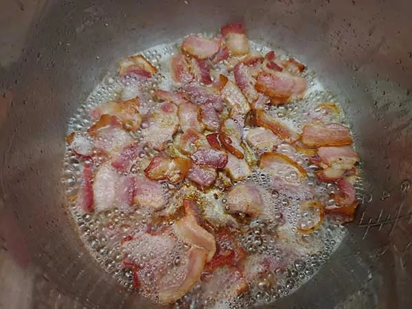 Bacon pieces browning in Instant Pot.