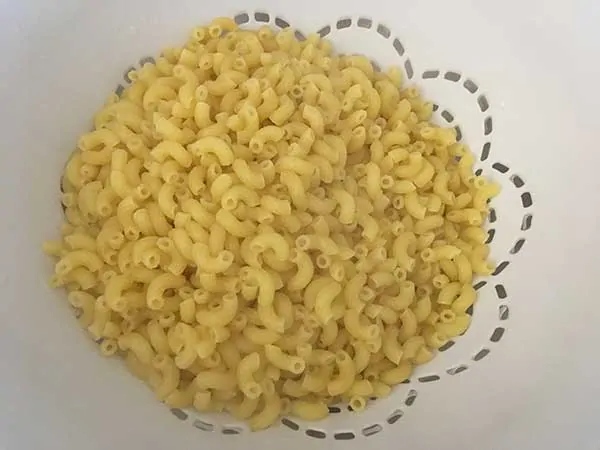 Cooked elbow pasta in colander.