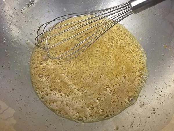 Eggs in mixing bowl with whisk.