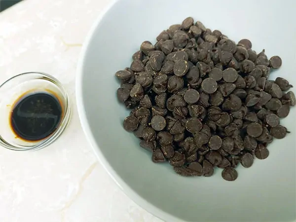 Vanilla extract and chocolate chips in separate small bowls