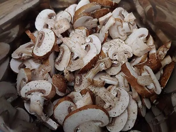 Sliced mushrooms seasoned with salt and pepper.