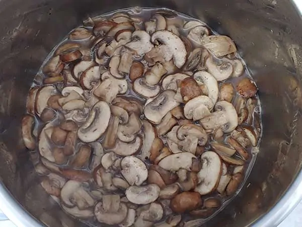 Mushrooms sautéing in pot.