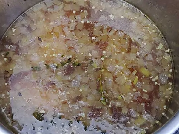 Chicken stock with cooked aromatics.