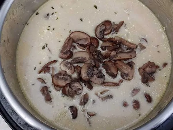 Cooked sliced mushrooms on top of creamy broth.
