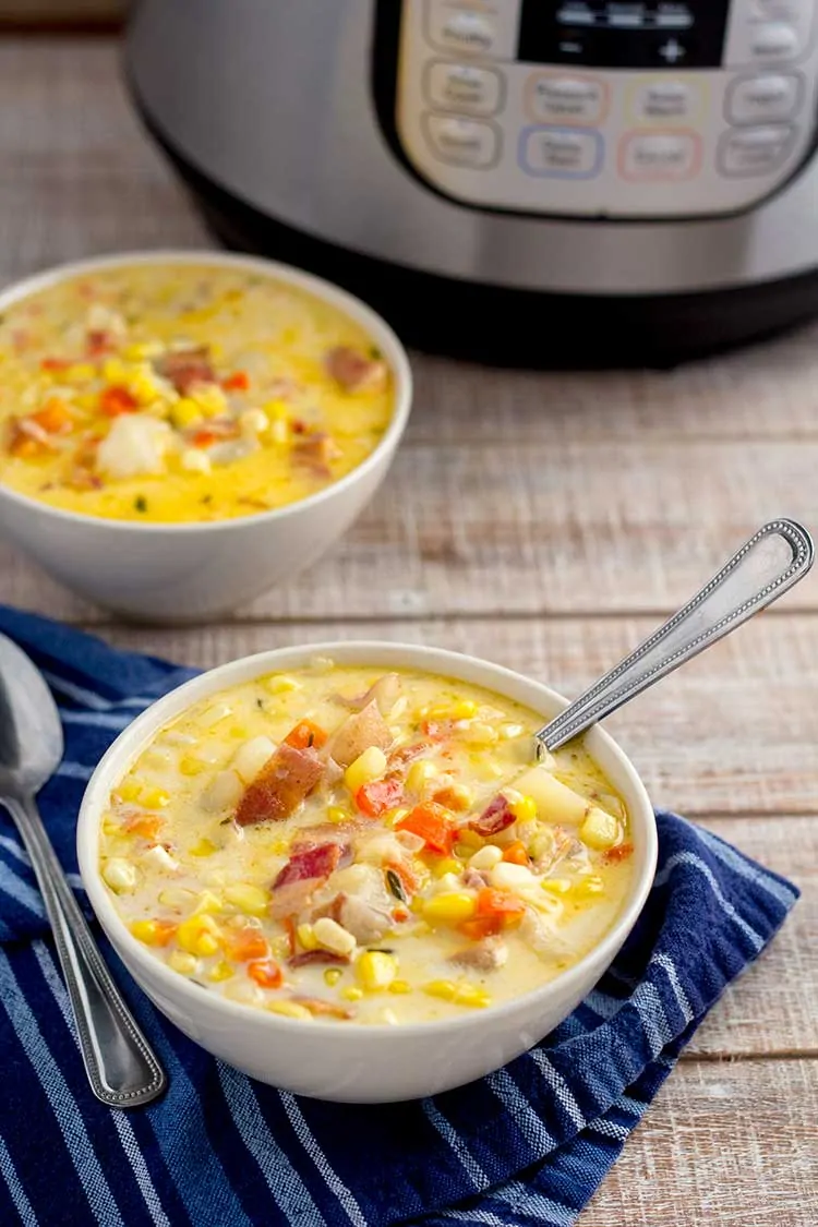 Two bowls of corn chowder with Instant Pot in background.