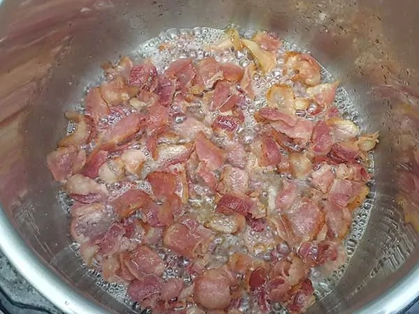 Crispy bacon pieces cooking in Instant Pot.