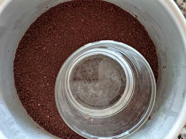Pressing crust down with glass.